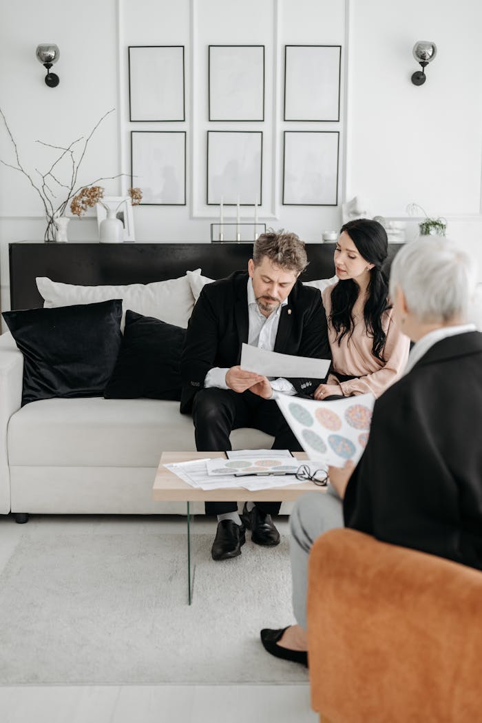 Couple reviewing documents with a social worker at home, discussing adoption.